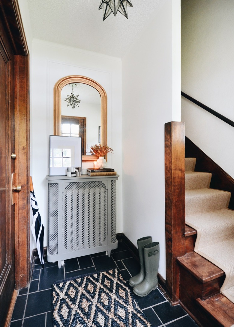 covered radiator and mirror in entryway