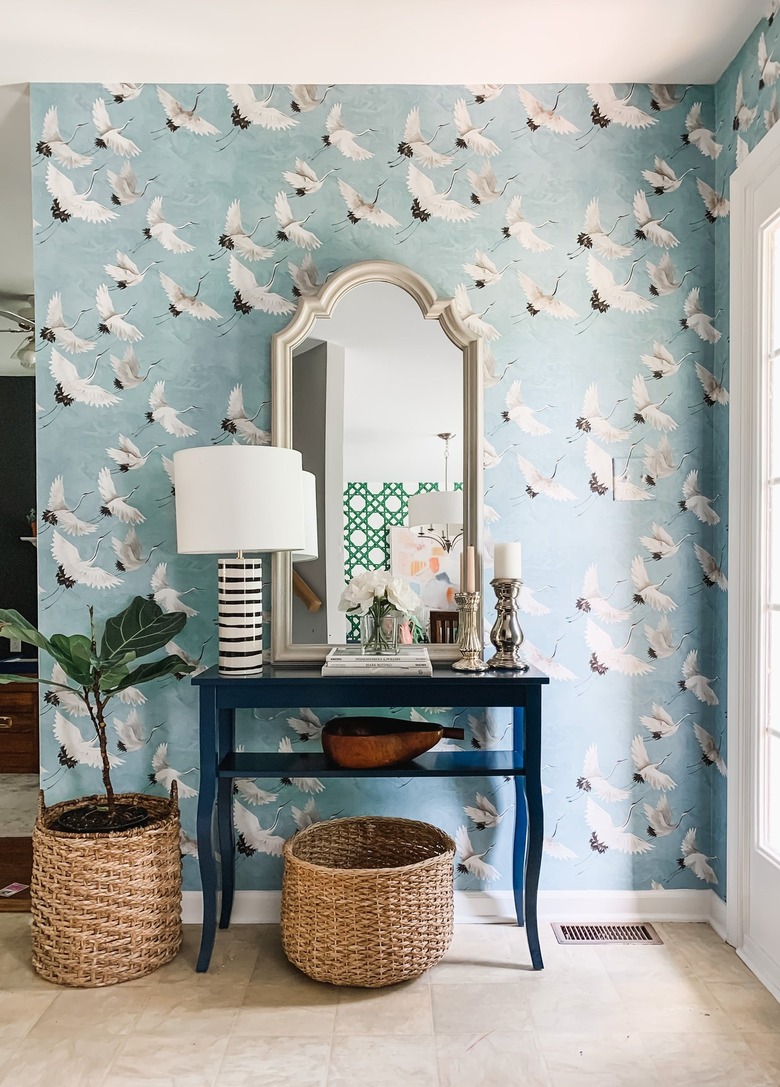 crane wallpaper and mirror in entryway