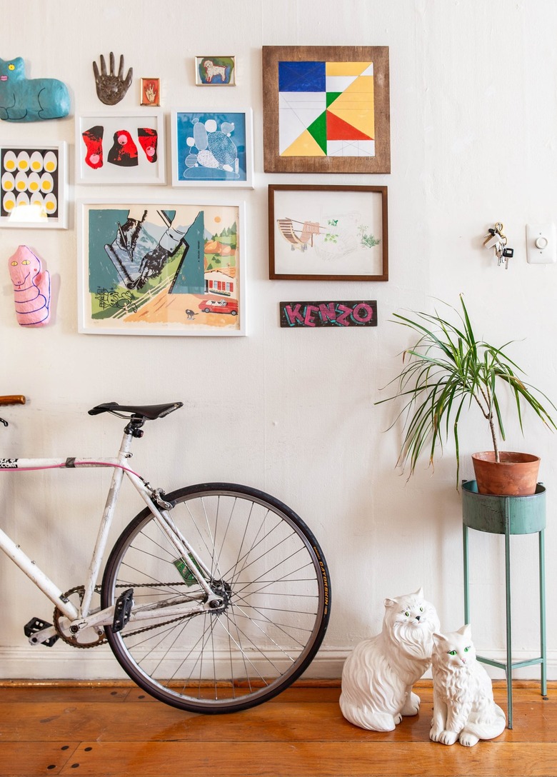 Hallway Gallery Wall Ideas with Bicycle leaning against hallway wall with artwork