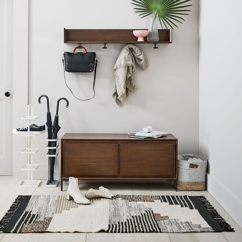 hallway with shelf and console and black and white rug