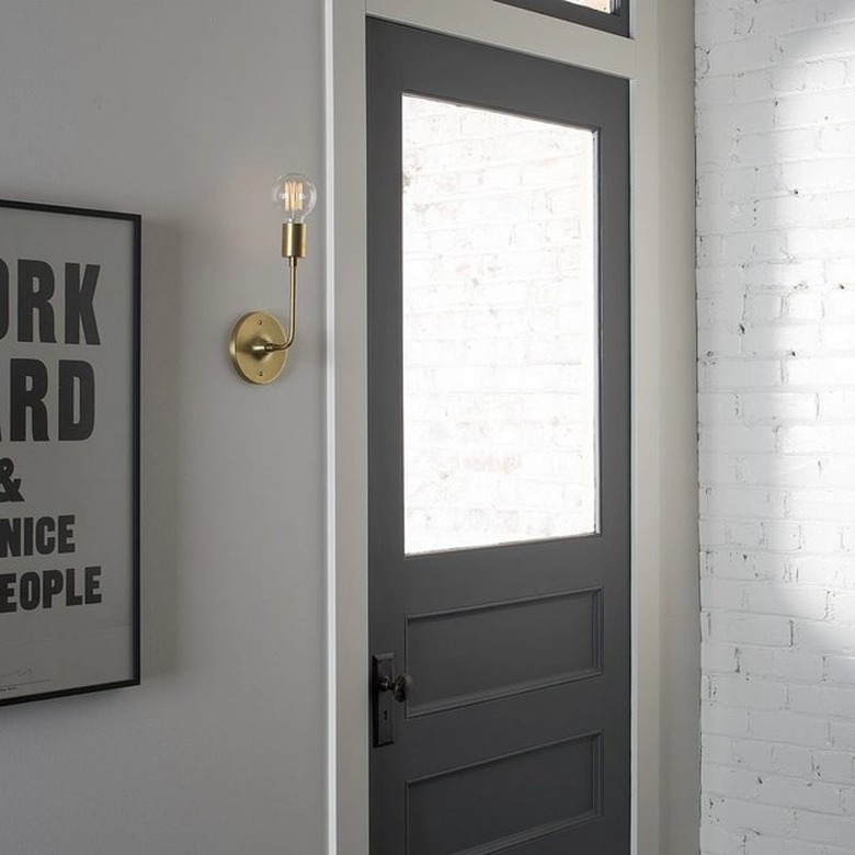 door with gold wall sconce nearby