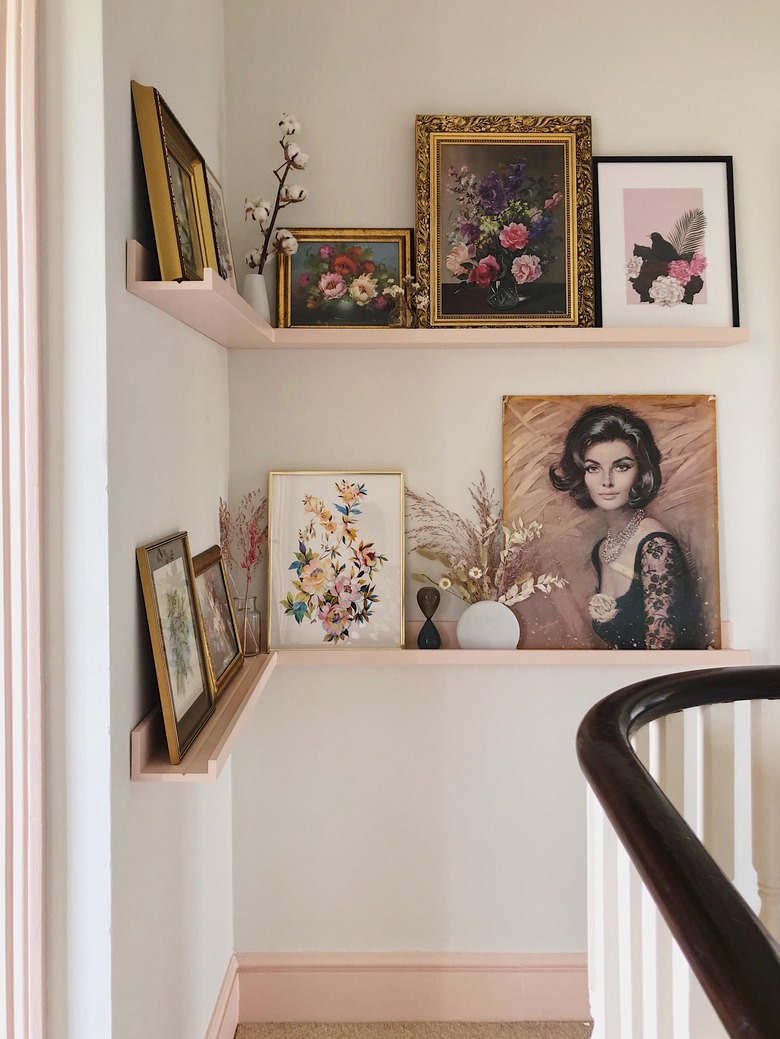 Hallway Makeover Ideas in pink and white hallway with corner picture ledge and vintage art