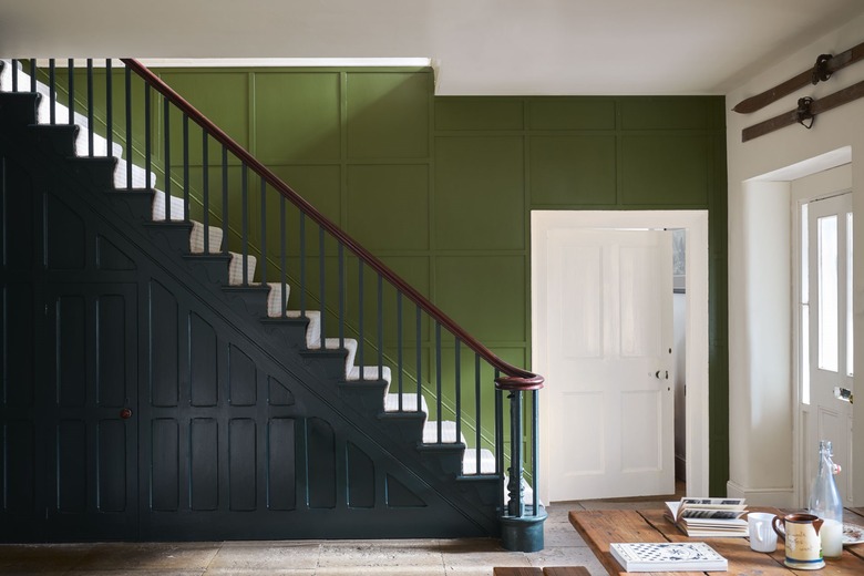 Green wall and black staircase with white door