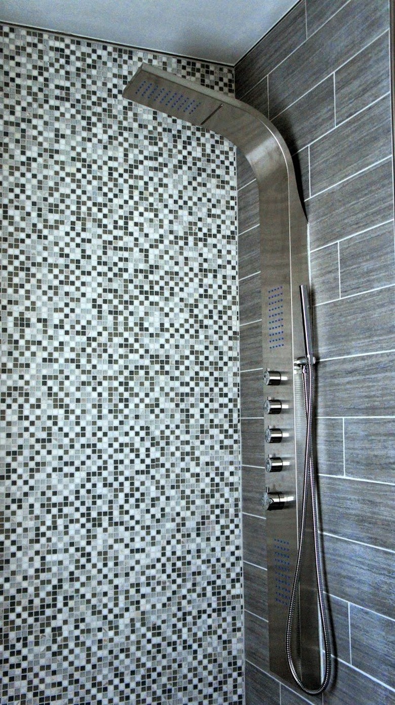 Shower panel with handheld shower head and body sprays with contemporary tiled shower wall