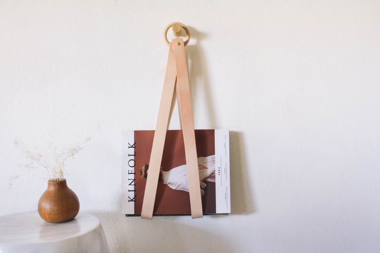 diy leather & wood magazine holder hanging on wall next to wood vase