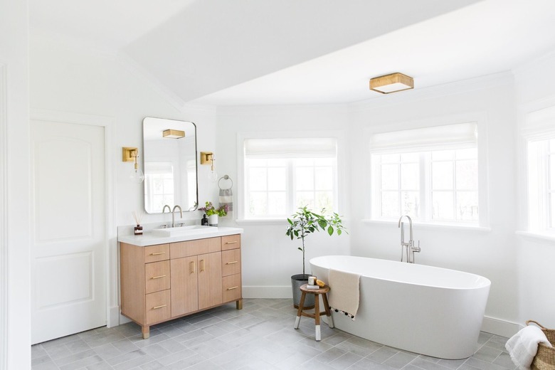 bathroom curtain idea in large bright space with a soaking tub, a wood vanity, and lots of windows