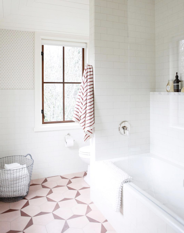 bathroom curtain idea in mostly white bathroom with pink floor tiles and a vinyl roller shade on the window