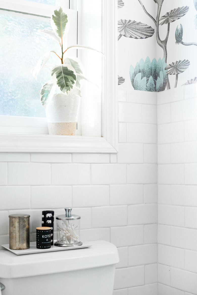 bathroom curtain idea with white subway tile, floral wallpaper, and a window above the toilet