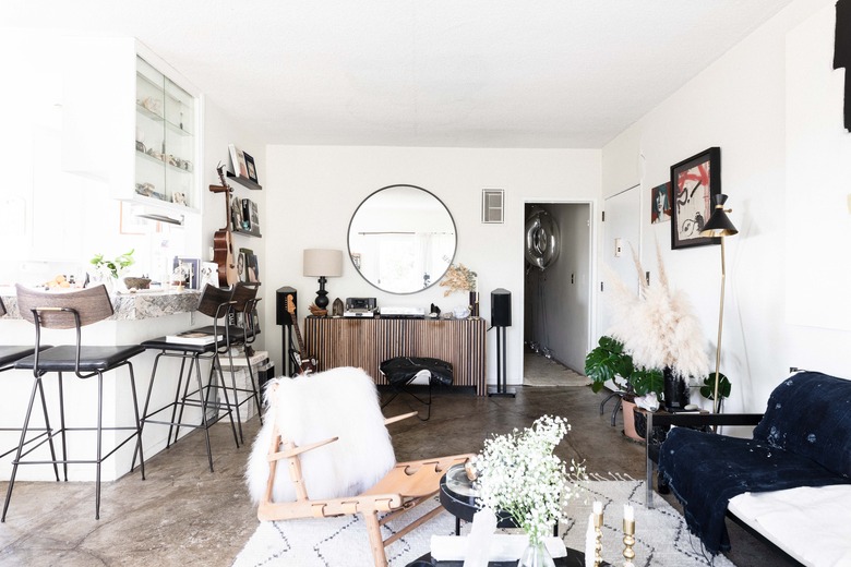 living room with concrete floors and rug leading into dining room