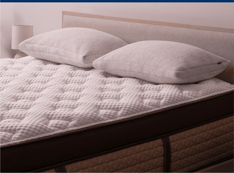 A Helix Midnight Elite mattress on top of a beige bed frame