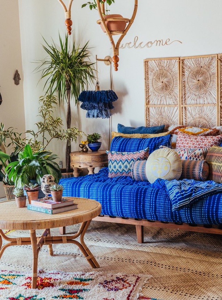 daybed in the living room idea with a wood daybed with a thick blue cushion and lots of throw pillows