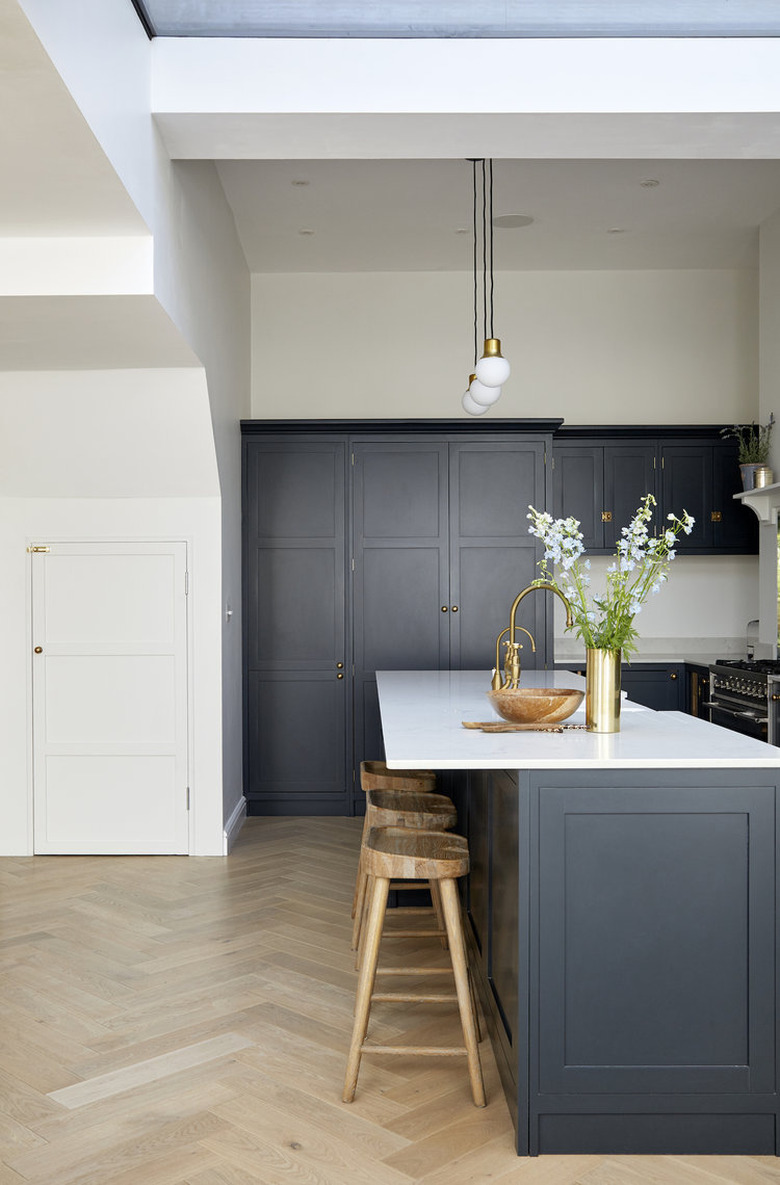 Herringbone kitchen floor with navy blue cabinets and simple decor