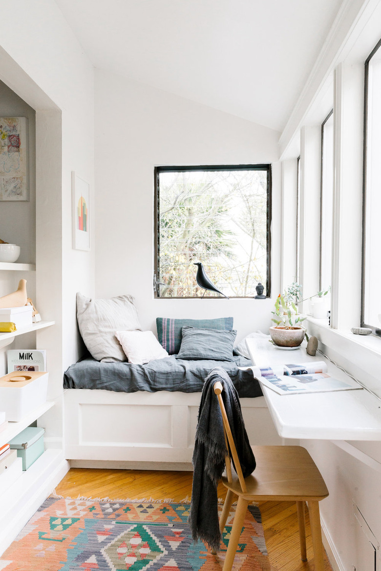 small home office with floating shelf desk and seating area