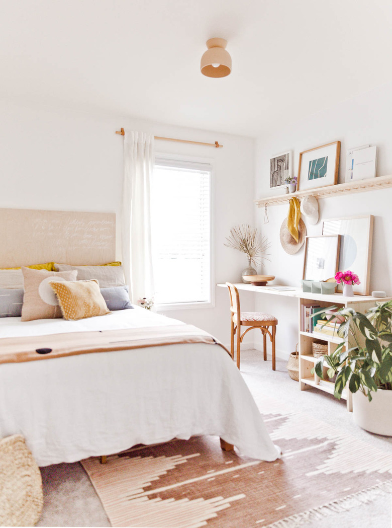 small home office in a guest bedroom near window with potted plant