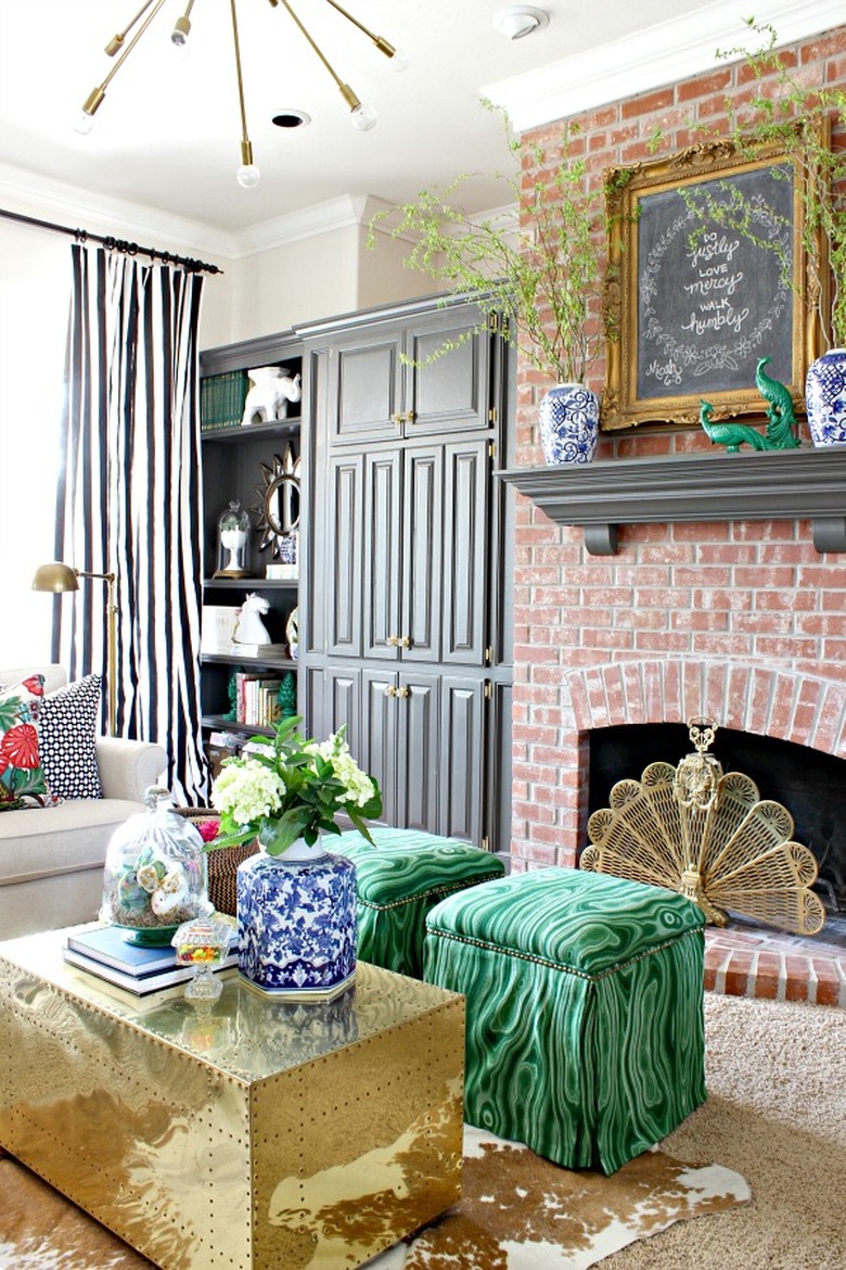 Hollywood Regency living room with exposed brick fireplace and gold coffee table