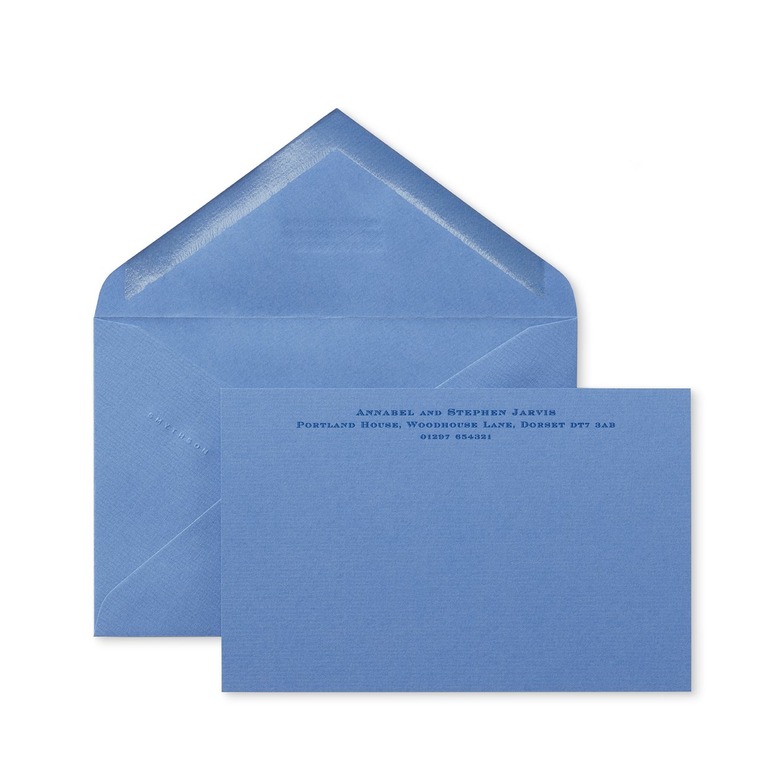 A medium-light blue envelope and matching card with a name and address on it.