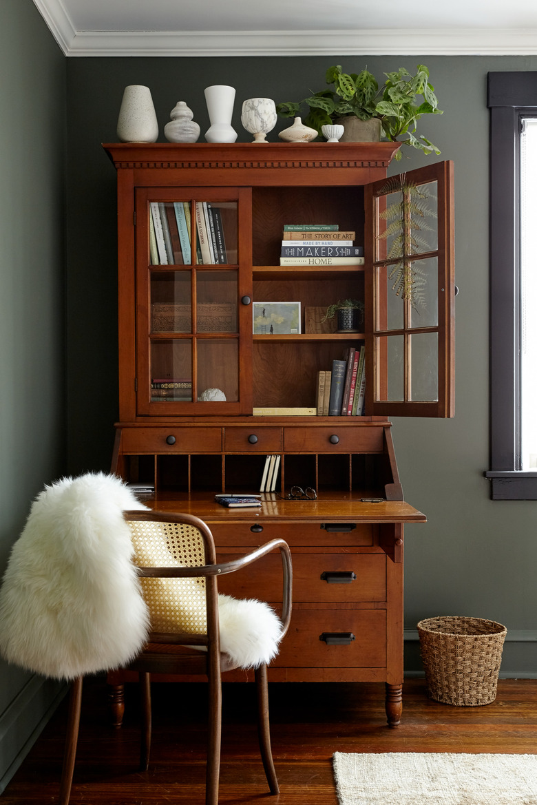 green room with vintage wooden hutch with bookshelf on top