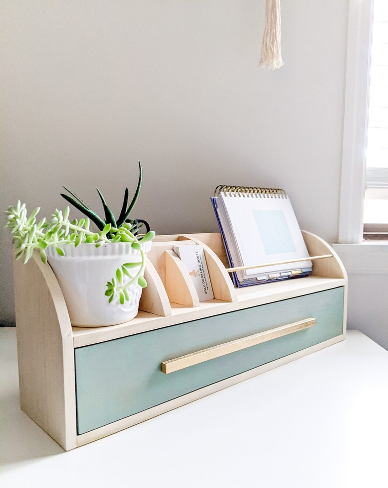 wood desk organizer with green drawer and small houseplant