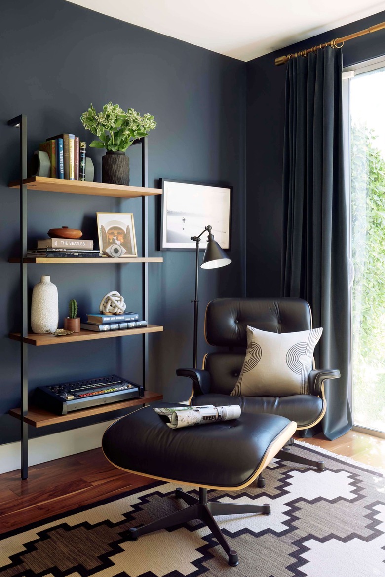 black industrial floor lamp next to black chair in midcentury office