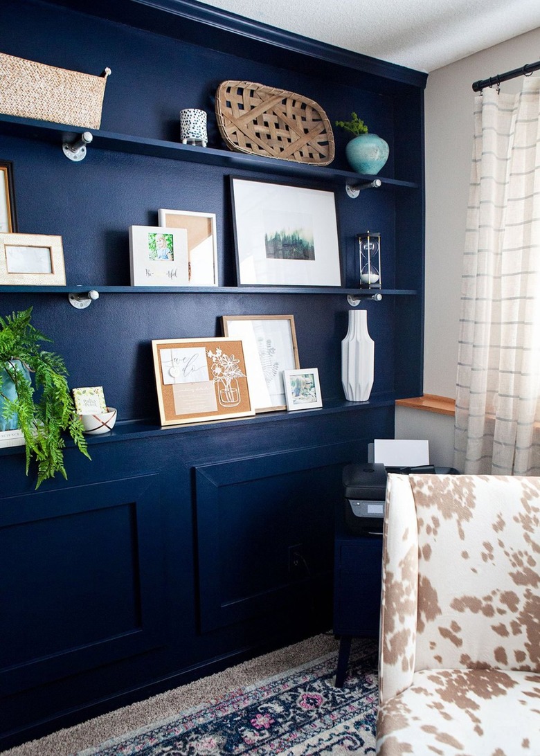 blue monochromatic home office with matching wall shelves