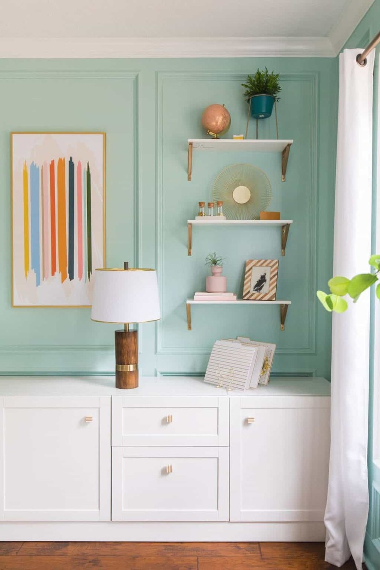 white open shelves with brass brackets in sea green office