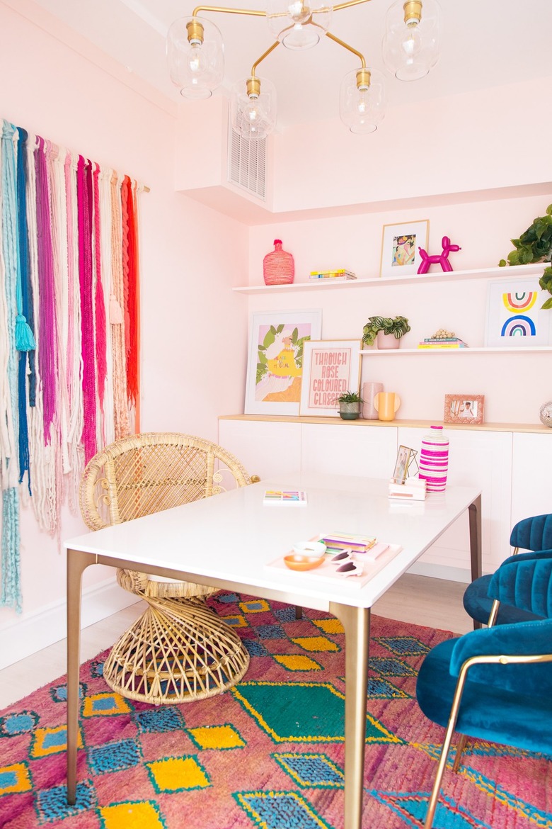 a colorful office with rainbow wall hanging