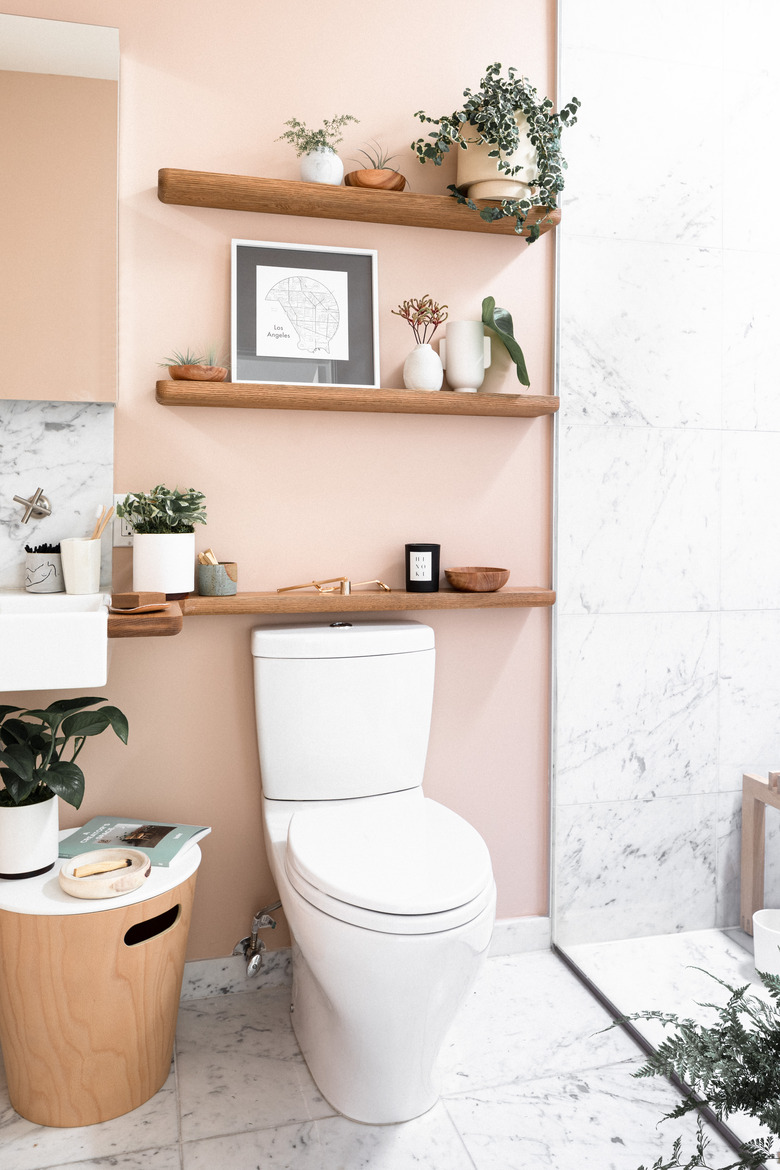 Pink bathroom with trio of shelves above toilet