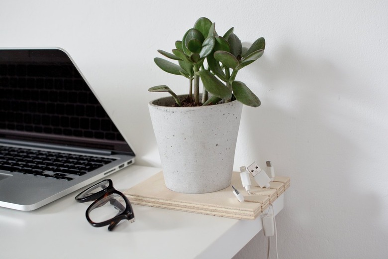 Homeschool Organization with a cable organizer made out of a square of plywood with cables hanging from it and a potted plant inset