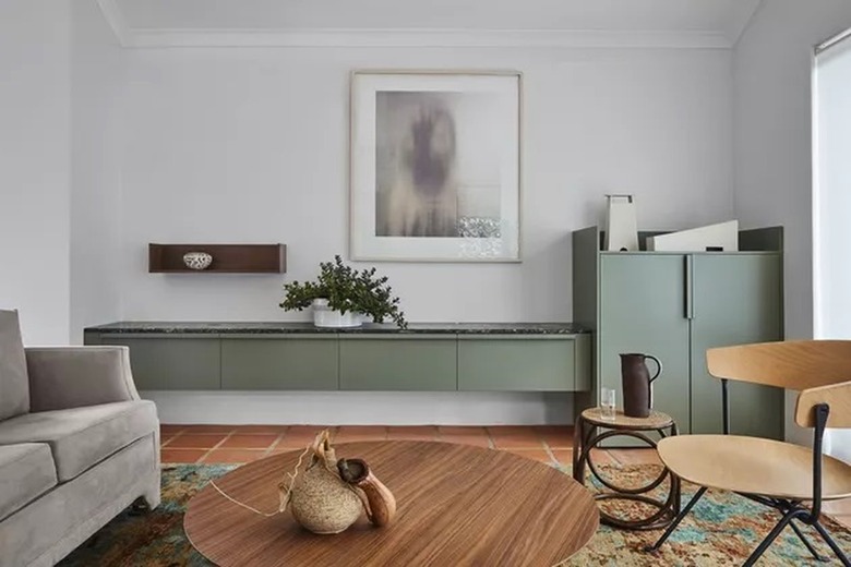 Taupe sofa with olive wall cabinets and terracotta rug