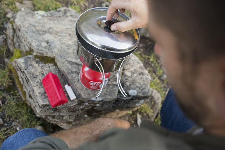 Close up man cooking with camping stove