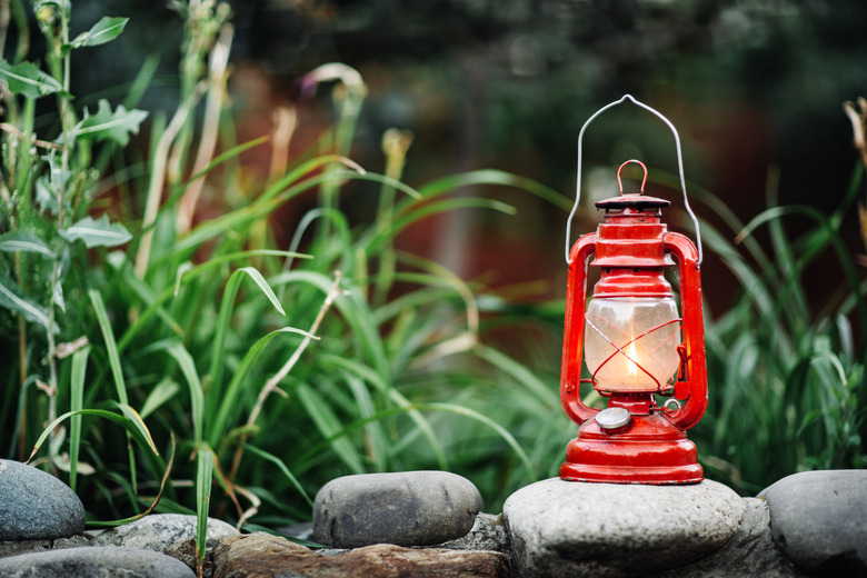 Red kerosene lamp isolated on garden background