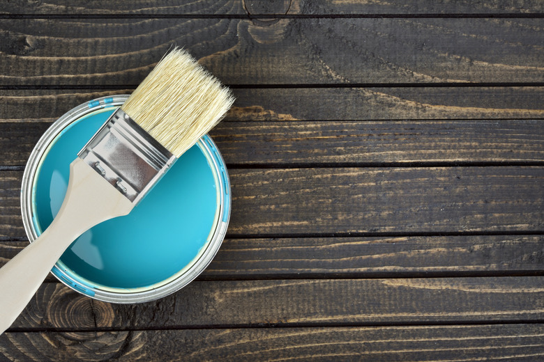 Paint bucket and brush on table