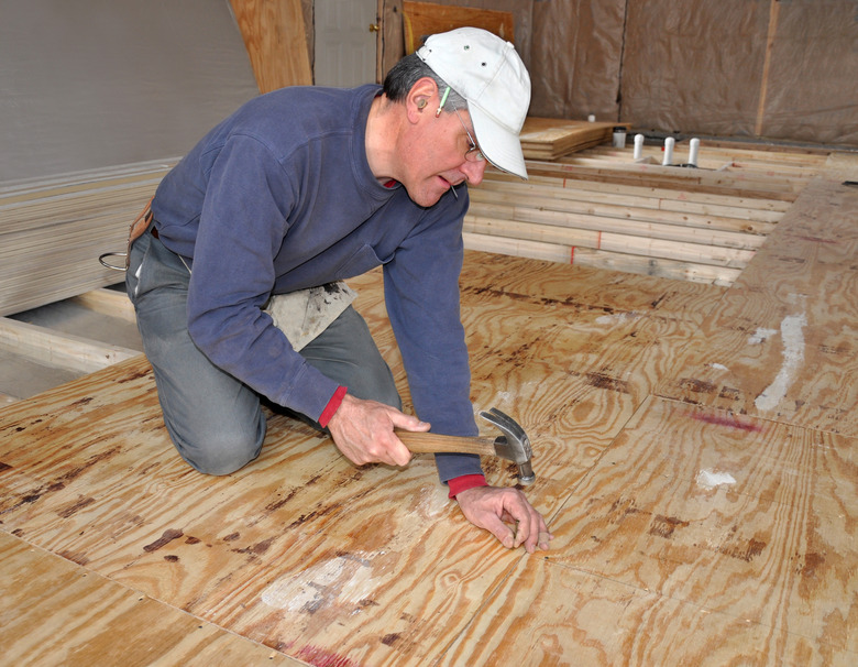 Man nailing down plywood subfloor.