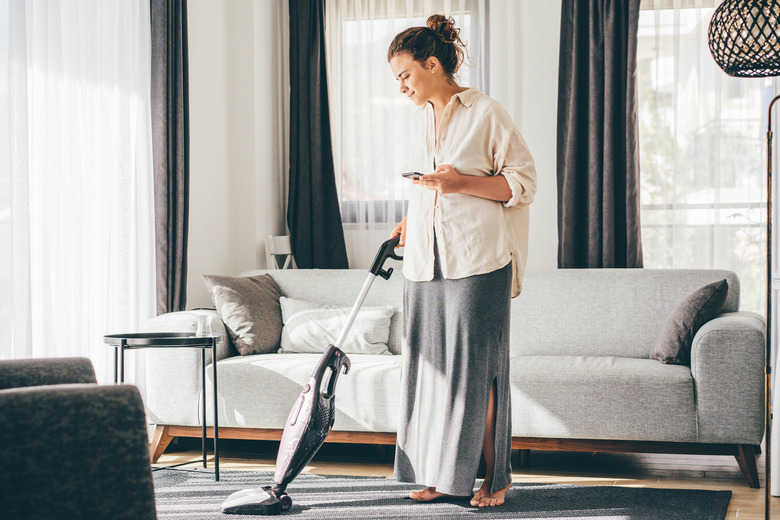 Vacuuming while talking on cell phone.