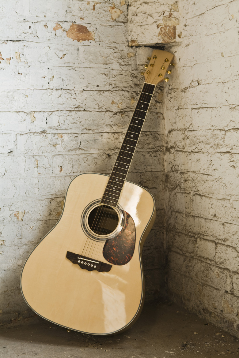 Guitar leaning against brick wall