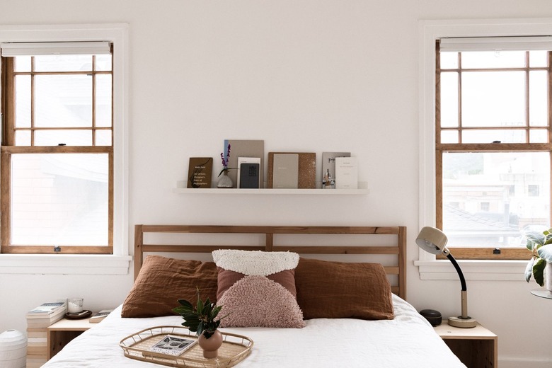 white duvet on a bed with bookshelf in a minimalist bedroom