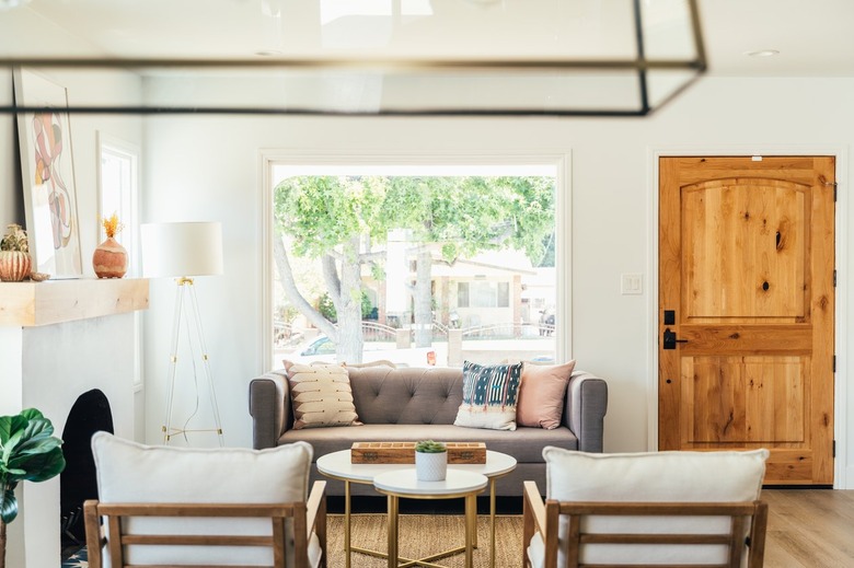 Living room with small gray couch, two accent chairs, coffee table.