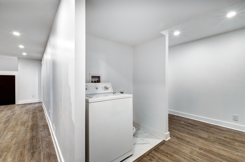 Finished basement with concealed laundry area.