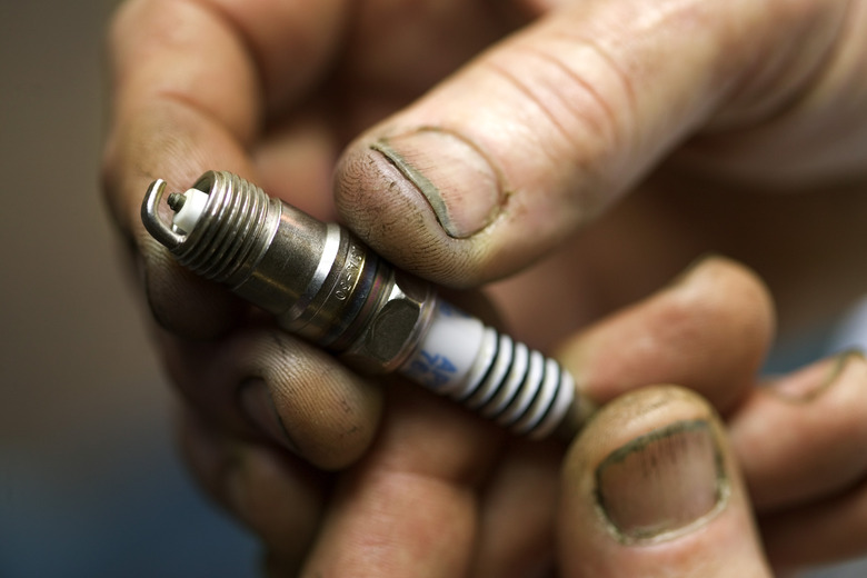 Hands holding spark plug