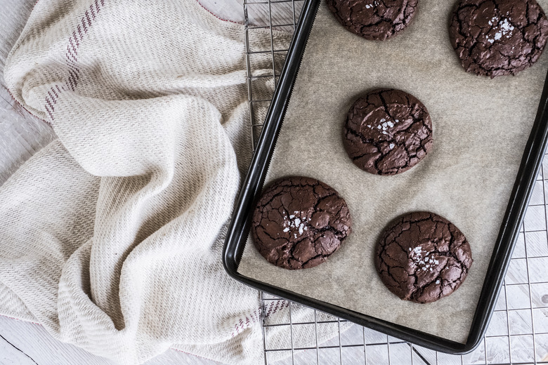 Baked chocolate brownies on a baking tray placed on a wire cooling rack.