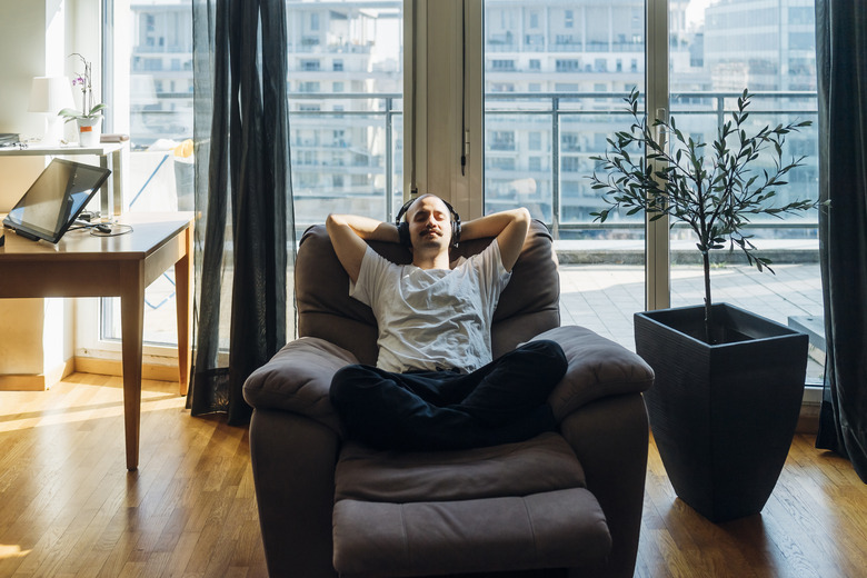 Young man relaxing on a reclining chair at home.