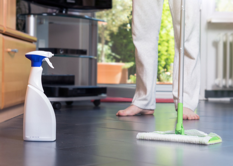 Low Section Of Man Cleaning Floor At Home