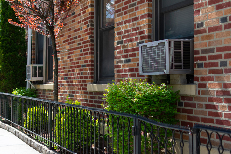 Outdoor Window Air Conditioning Units on an Old Brick New York City Apartment Building during Spring