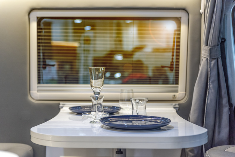 Dining table, plates, and glasses inside camper trailer.