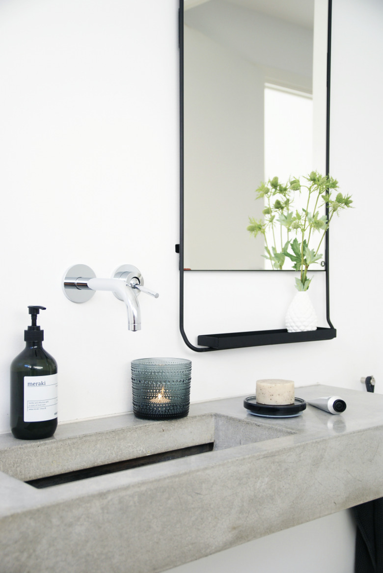 minimalist bathroom with luxe accessories on concrete countertop