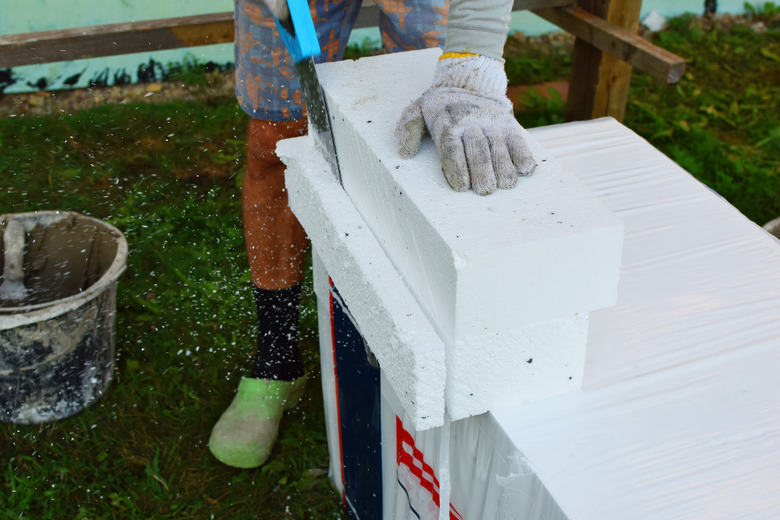 Worker sawing white foam sheet