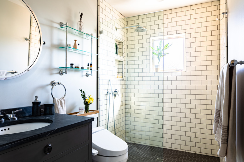 bathroom with open shower with subway wall tile, toilet and bathroom vanity sink in the picture