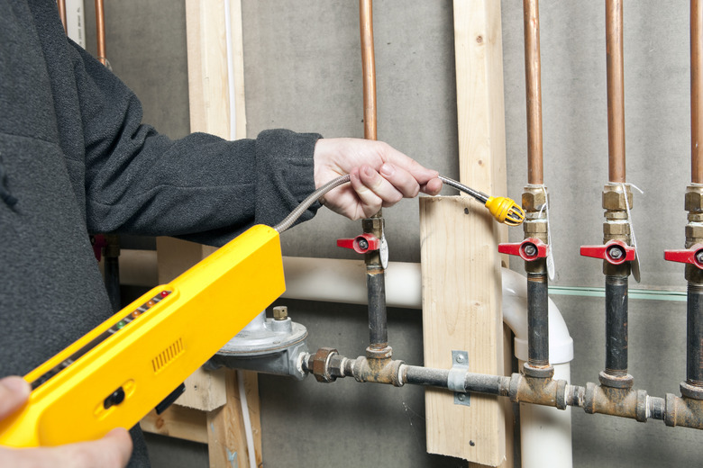 Worker Using a Leak Detector near House Gas Lines