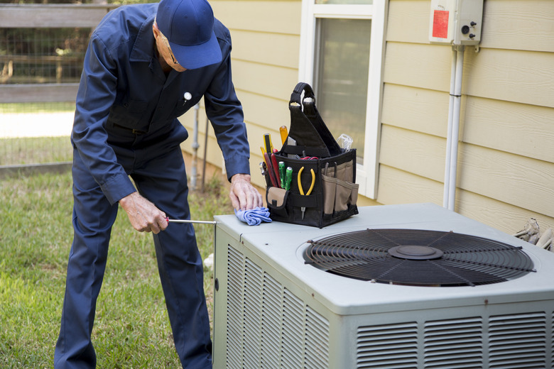 Technician servicing outside AC unit.