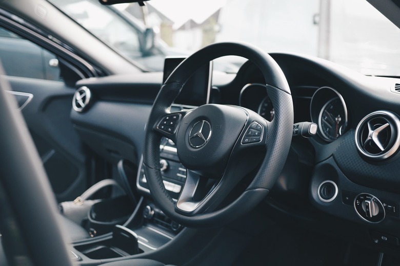 all black mercedes car interior showing steering wheel and driver's seat